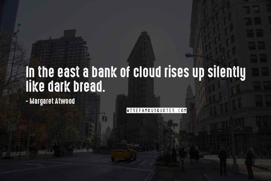 Margaret Atwood Quotes: In the east a bank of cloud rises up silently like dark bread.