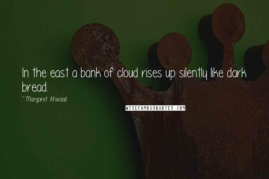 Margaret Atwood Quotes: In the east a bank of cloud rises up silently like dark bread.