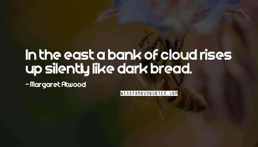 Margaret Atwood Quotes: In the east a bank of cloud rises up silently like dark bread.