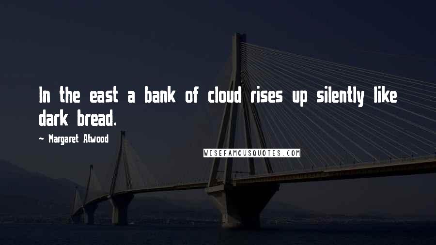 Margaret Atwood Quotes: In the east a bank of cloud rises up silently like dark bread.