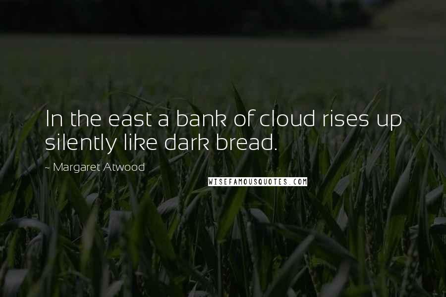 Margaret Atwood Quotes: In the east a bank of cloud rises up silently like dark bread.