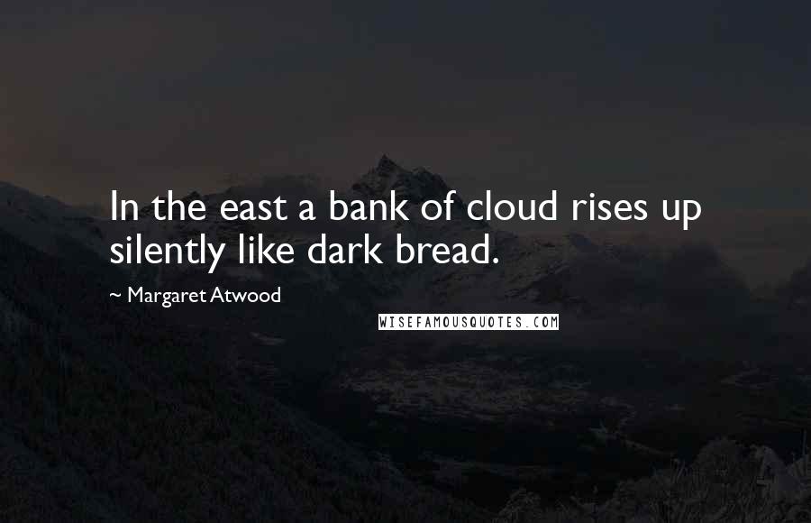 Margaret Atwood Quotes: In the east a bank of cloud rises up silently like dark bread.