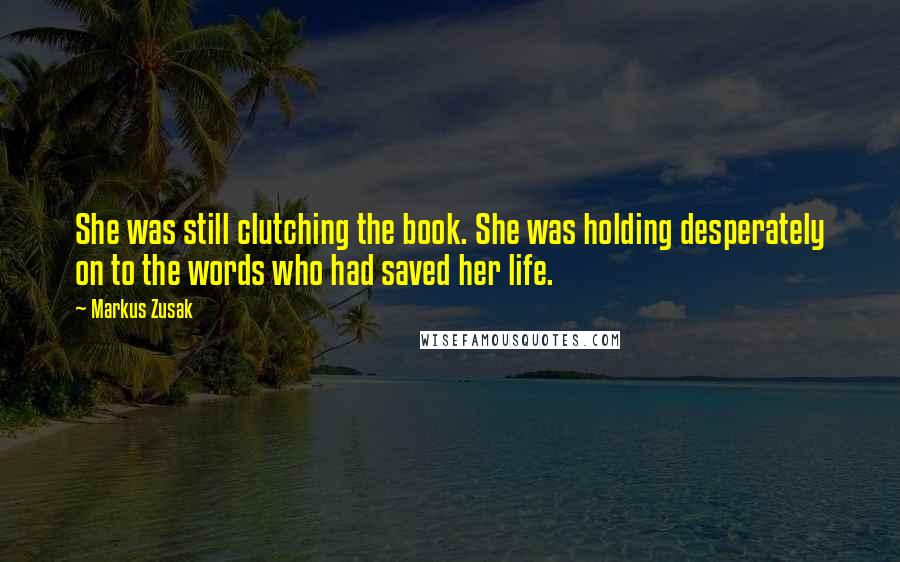 Markus Zusak Quotes: She was still clutching the book. She was holding desperately on to the words who had saved her life.