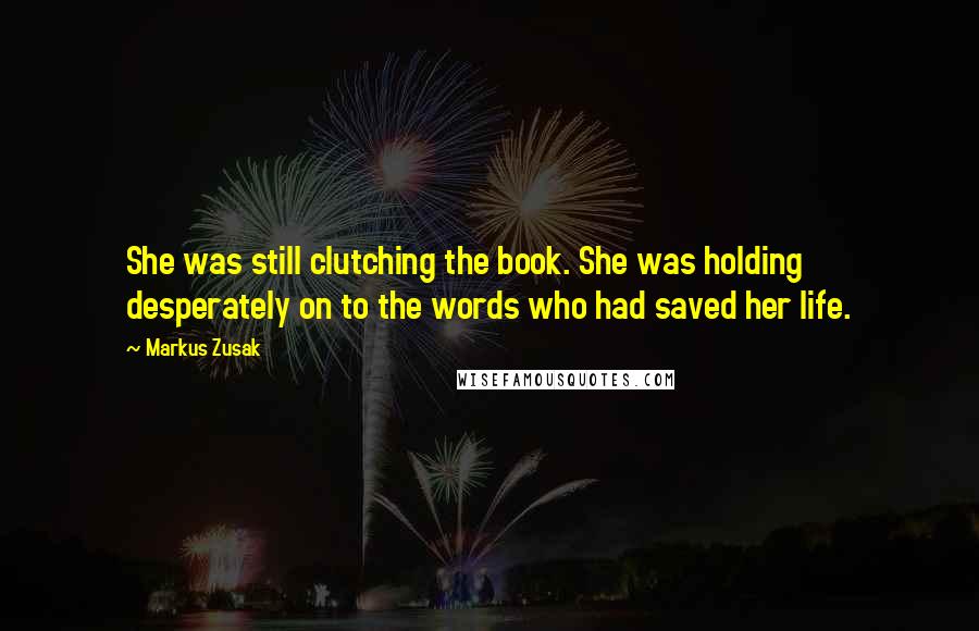 Markus Zusak Quotes: She was still clutching the book. She was holding desperately on to the words who had saved her life.