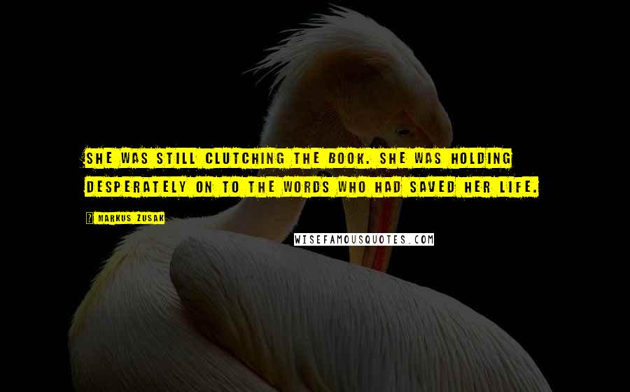 Markus Zusak Quotes: She was still clutching the book. She was holding desperately on to the words who had saved her life.