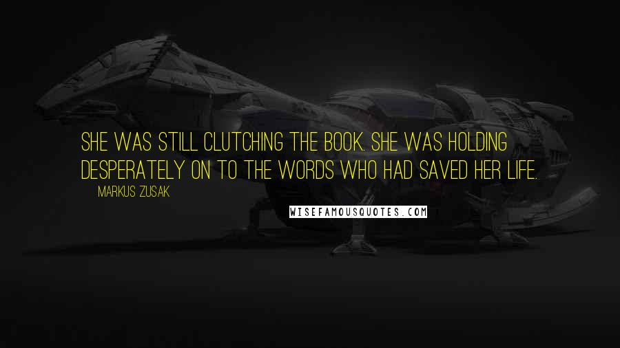 Markus Zusak Quotes: She was still clutching the book. She was holding desperately on to the words who had saved her life.