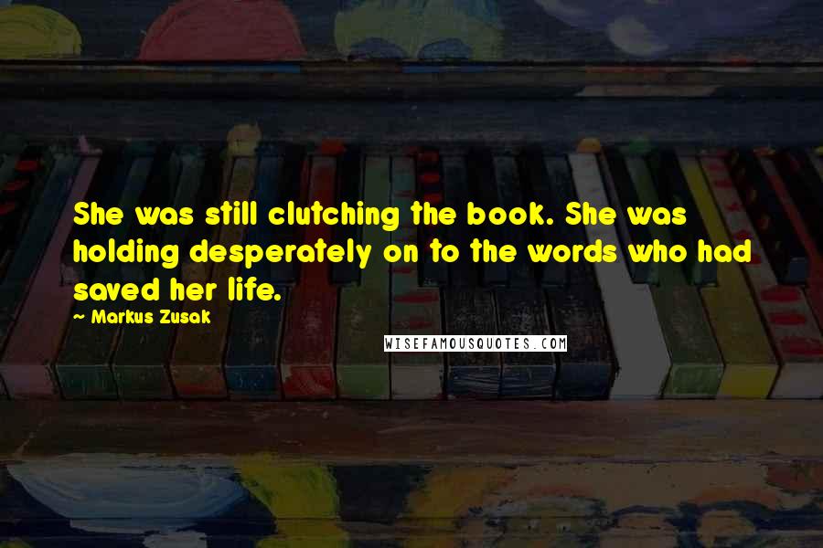 Markus Zusak Quotes: She was still clutching the book. She was holding desperately on to the words who had saved her life.