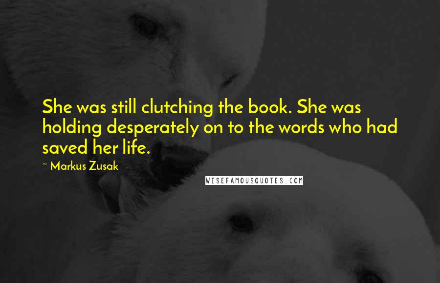 Markus Zusak Quotes: She was still clutching the book. She was holding desperately on to the words who had saved her life.