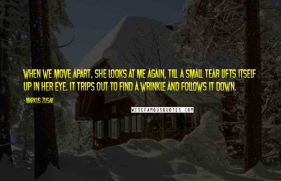 Markus Zusak Quotes: When we move apart, she looks at me again, till a small tear lifts itself up in her eye. It trips out to find a wrinkle and follows it down.