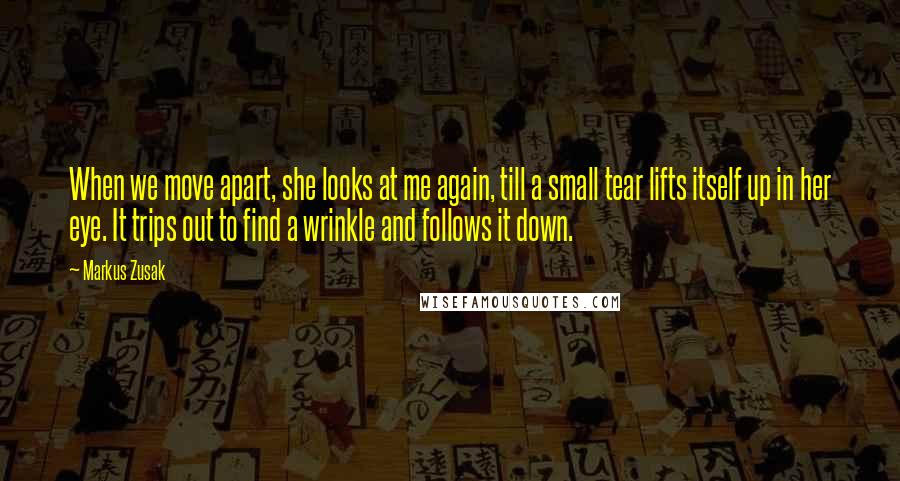 Markus Zusak Quotes: When we move apart, she looks at me again, till a small tear lifts itself up in her eye. It trips out to find a wrinkle and follows it down.