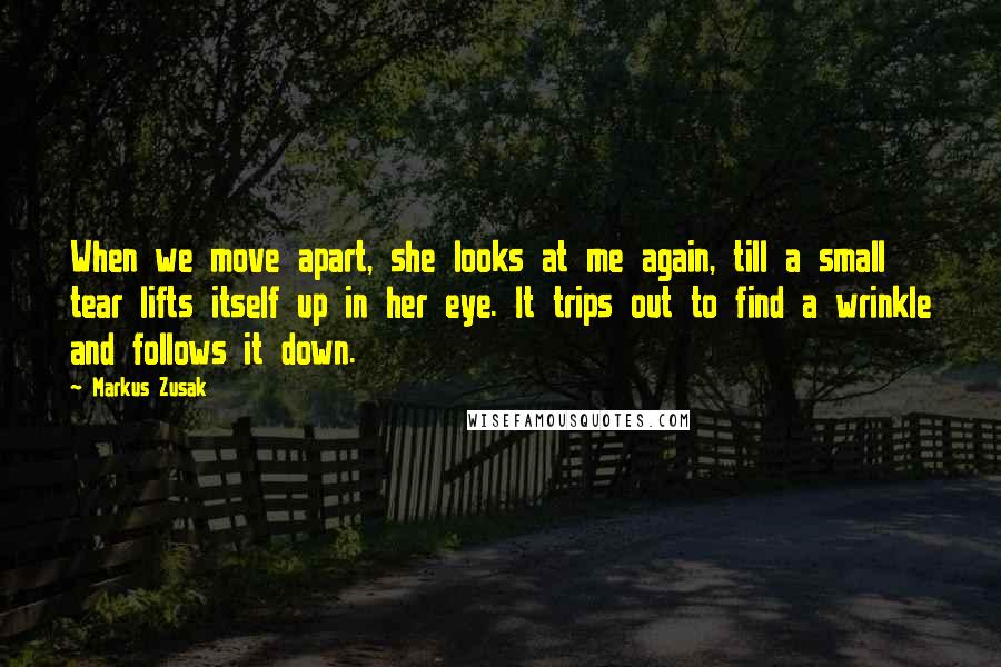 Markus Zusak Quotes: When we move apart, she looks at me again, till a small tear lifts itself up in her eye. It trips out to find a wrinkle and follows it down.