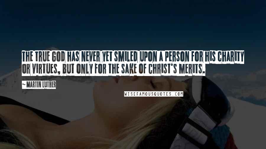 Martin Luther Quotes: The true God has never yet smiled upon a person for his charity or virtues, but only for the sake of Christ's merits.