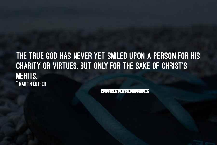 Martin Luther Quotes: The true God has never yet smiled upon a person for his charity or virtues, but only for the sake of Christ's merits.