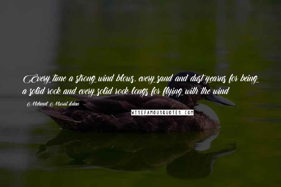 Mehmet Murat Ildan Quotes: Every time a strong wind blows, every sand and dust yearns for being a solid rock and every solid rock longs for flying with the wind!