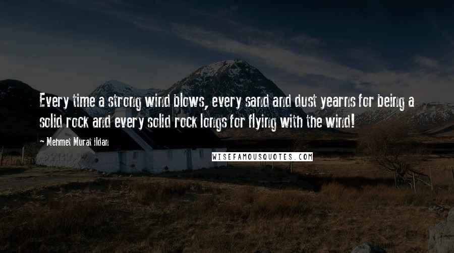 Mehmet Murat Ildan Quotes: Every time a strong wind blows, every sand and dust yearns for being a solid rock and every solid rock longs for flying with the wind!