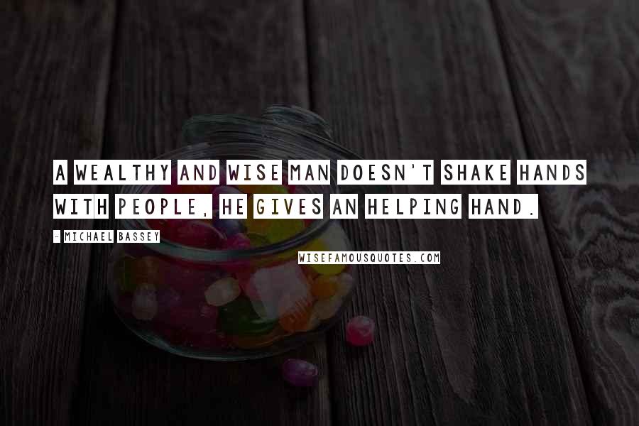 Michael Bassey Quotes: A wealthy and wise man doesn't shake hands with people, he gives an helping hand.