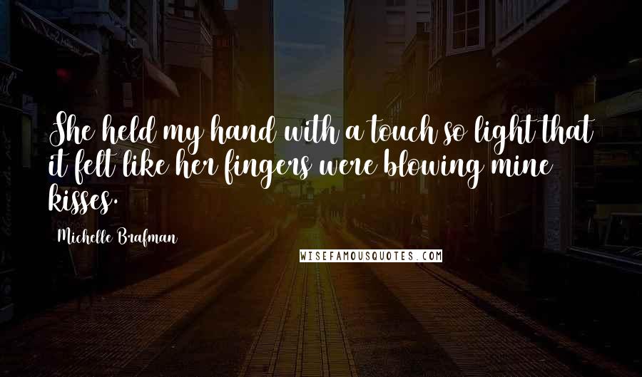 Michelle Brafman Quotes: She held my hand with a touch so light that it felt like her fingers were blowing mine kisses.