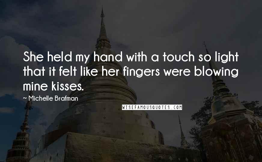 Michelle Brafman Quotes: She held my hand with a touch so light that it felt like her fingers were blowing mine kisses.