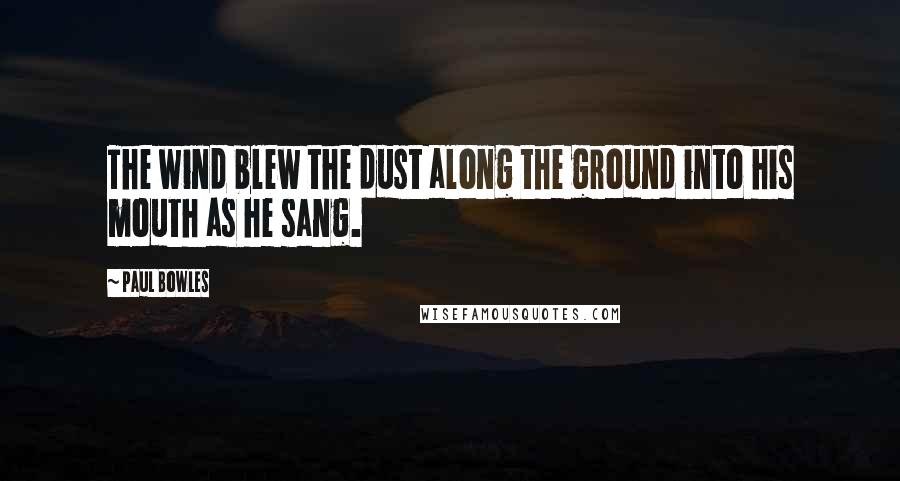 Paul Bowles Quotes: The wind blew the dust along the ground into his mouth as he sang.