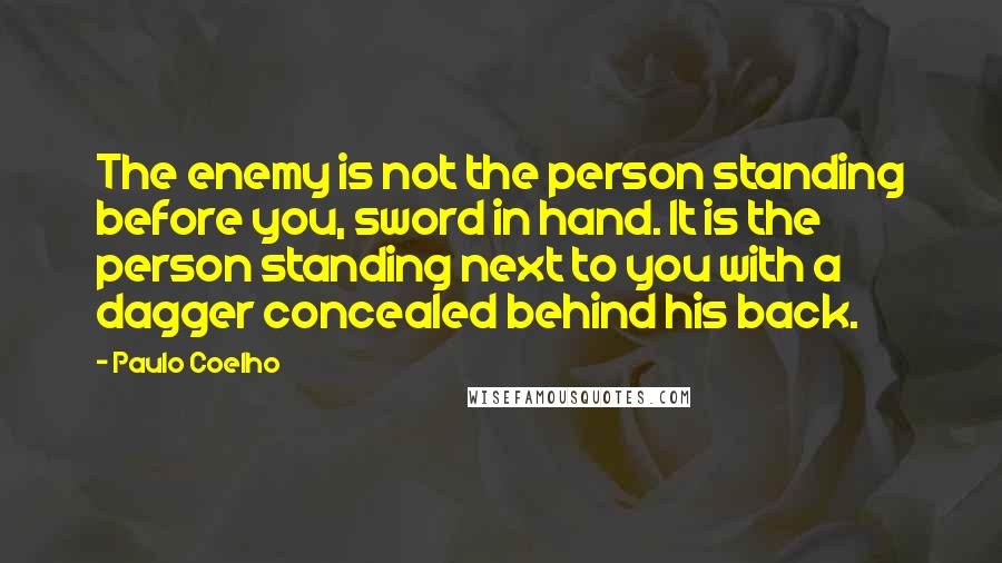 Paulo Coelho Quotes: The enemy is not the person standing before you, sword in hand. It is the person standing next to you with a dagger concealed behind his back.