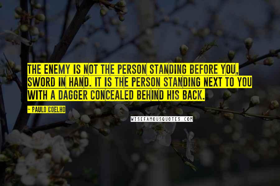 Paulo Coelho Quotes: The enemy is not the person standing before you, sword in hand. It is the person standing next to you with a dagger concealed behind his back.