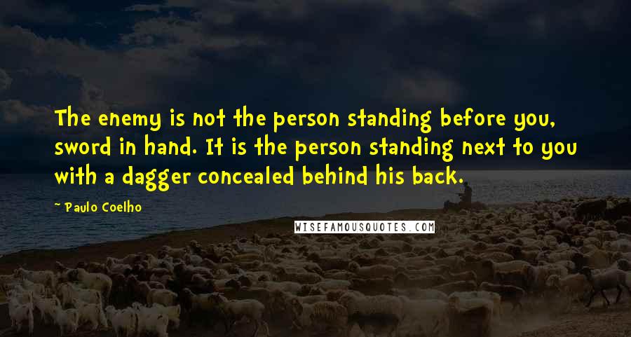 Paulo Coelho Quotes: The enemy is not the person standing before you, sword in hand. It is the person standing next to you with a dagger concealed behind his back.