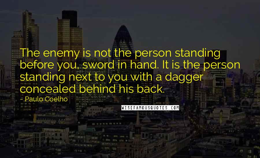 Paulo Coelho Quotes: The enemy is not the person standing before you, sword in hand. It is the person standing next to you with a dagger concealed behind his back.