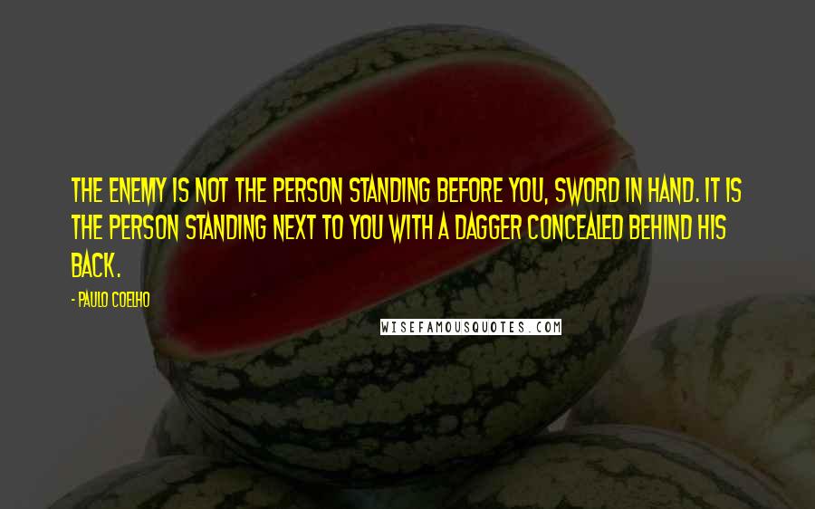 Paulo Coelho Quotes: The enemy is not the person standing before you, sword in hand. It is the person standing next to you with a dagger concealed behind his back.