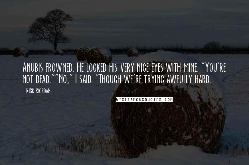 Rick Riordan Quotes: Anubis frowned. He locked his very nice eyes with mine. "You're not dead.""No," I said. "Though we're trying awfully hard.