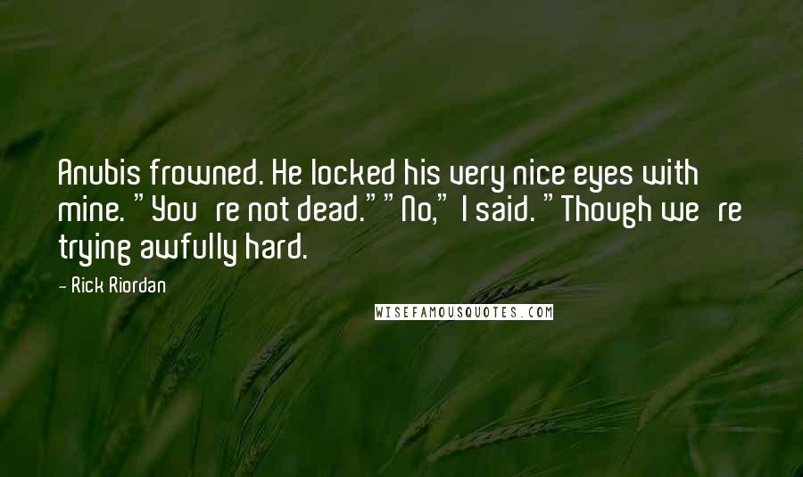 Rick Riordan Quotes: Anubis frowned. He locked his very nice eyes with mine. "You're not dead.""No," I said. "Though we're trying awfully hard.