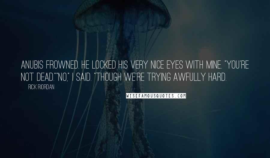 Rick Riordan Quotes: Anubis frowned. He locked his very nice eyes with mine. "You're not dead.""No," I said. "Though we're trying awfully hard.