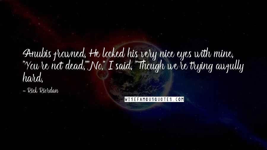 Rick Riordan Quotes: Anubis frowned. He locked his very nice eyes with mine. "You're not dead.""No," I said. "Though we're trying awfully hard.