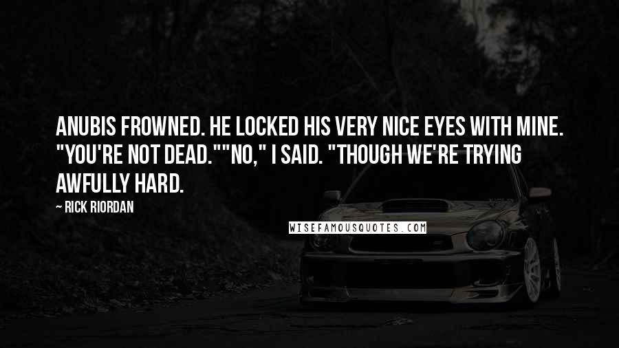 Rick Riordan Quotes: Anubis frowned. He locked his very nice eyes with mine. "You're not dead.""No," I said. "Though we're trying awfully hard.