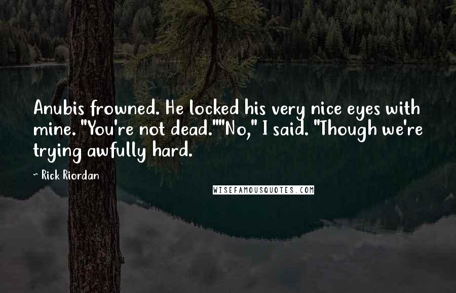 Rick Riordan Quotes: Anubis frowned. He locked his very nice eyes with mine. "You're not dead.""No," I said. "Though we're trying awfully hard.