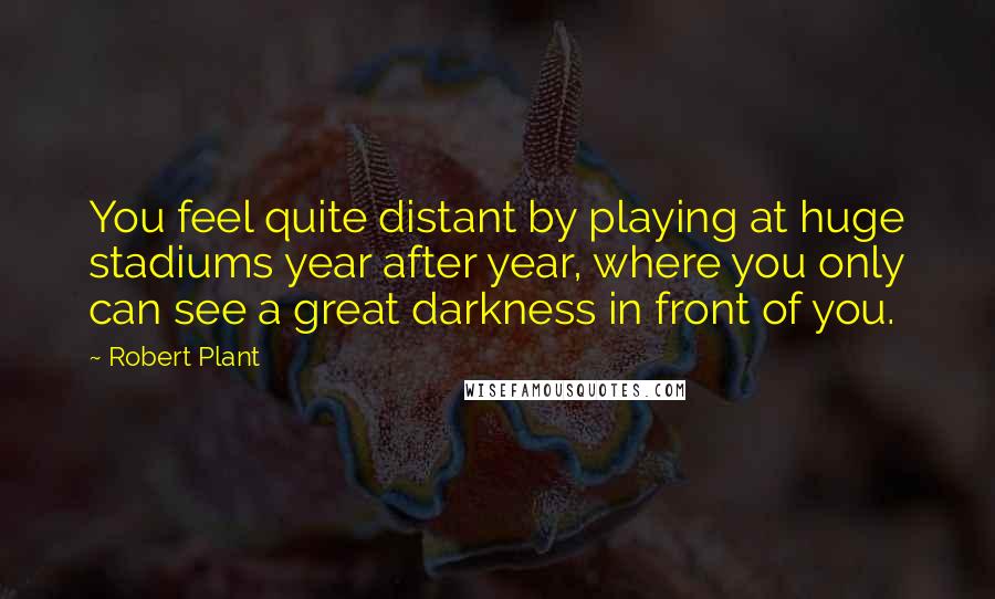 Robert Plant Quotes: You feel quite distant by playing at huge stadiums year after year, where you only can see a great darkness in front of you.