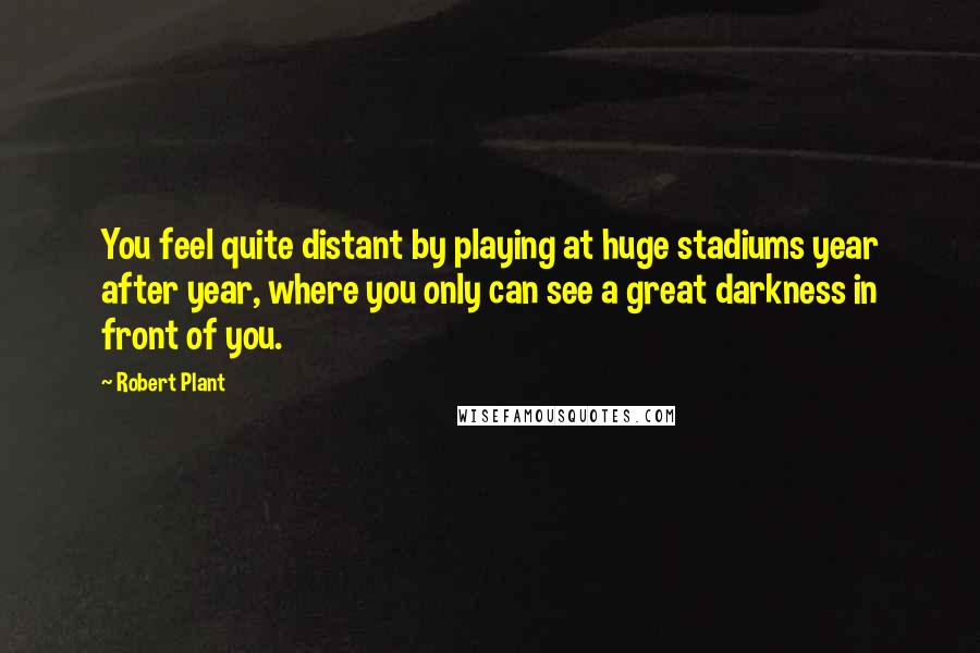 Robert Plant Quotes: You feel quite distant by playing at huge stadiums year after year, where you only can see a great darkness in front of you.