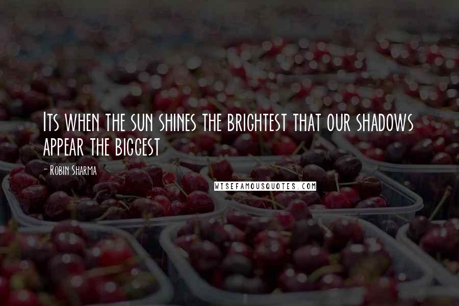 Robin Sharma Quotes: Its when the sun shines the brightest that our shadows appear the biggest