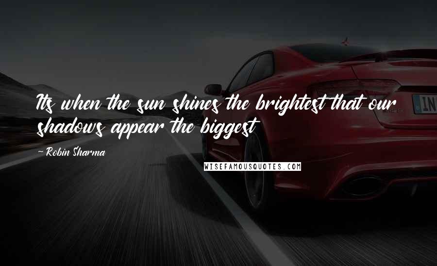 Robin Sharma Quotes: Its when the sun shines the brightest that our shadows appear the biggest