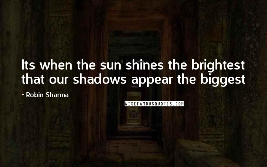 Robin Sharma Quotes: Its when the sun shines the brightest that our shadows appear the biggest