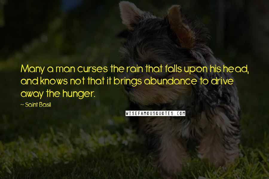 Saint Basil Quotes: Many a man curses the rain that falls upon his head, and knows not that it brings abundance to drive away the hunger.