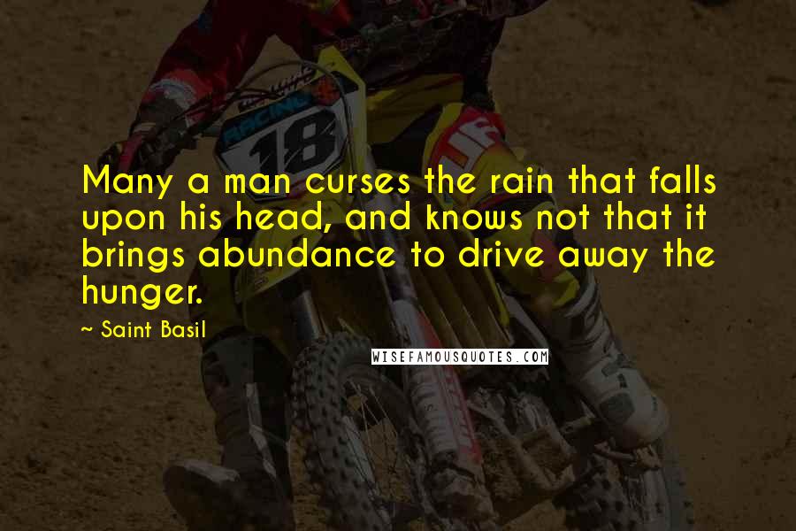 Saint Basil Quotes: Many a man curses the rain that falls upon his head, and knows not that it brings abundance to drive away the hunger.