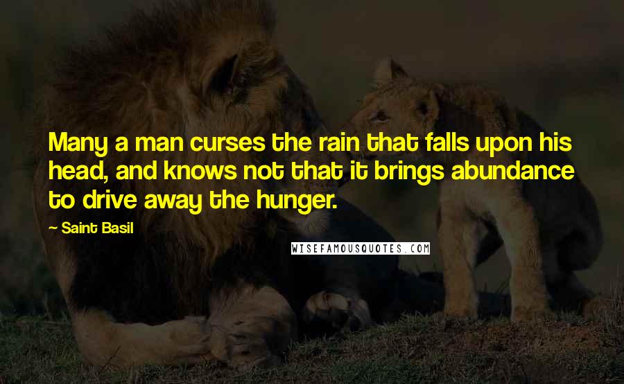 Saint Basil Quotes: Many a man curses the rain that falls upon his head, and knows not that it brings abundance to drive away the hunger.