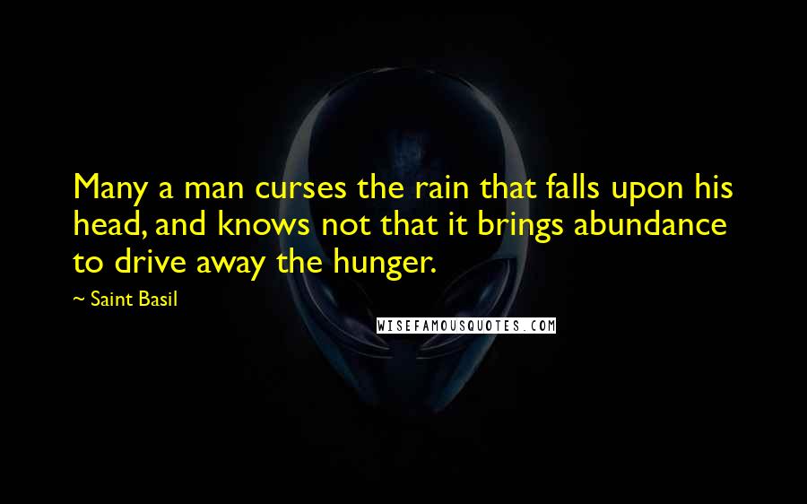 Saint Basil Quotes: Many a man curses the rain that falls upon his head, and knows not that it brings abundance to drive away the hunger.