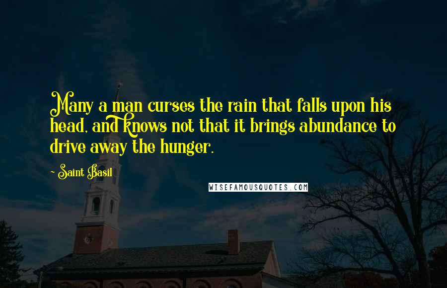 Saint Basil Quotes: Many a man curses the rain that falls upon his head, and knows not that it brings abundance to drive away the hunger.