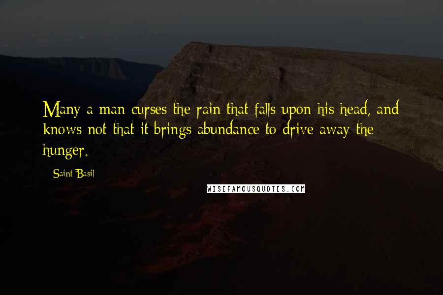 Saint Basil Quotes: Many a man curses the rain that falls upon his head, and knows not that it brings abundance to drive away the hunger.