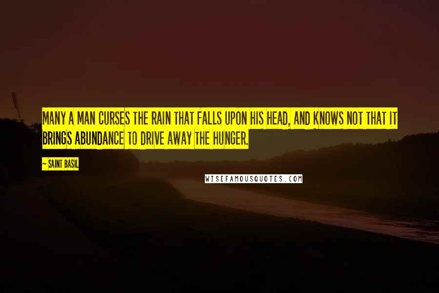 Saint Basil Quotes: Many a man curses the rain that falls upon his head, and knows not that it brings abundance to drive away the hunger.