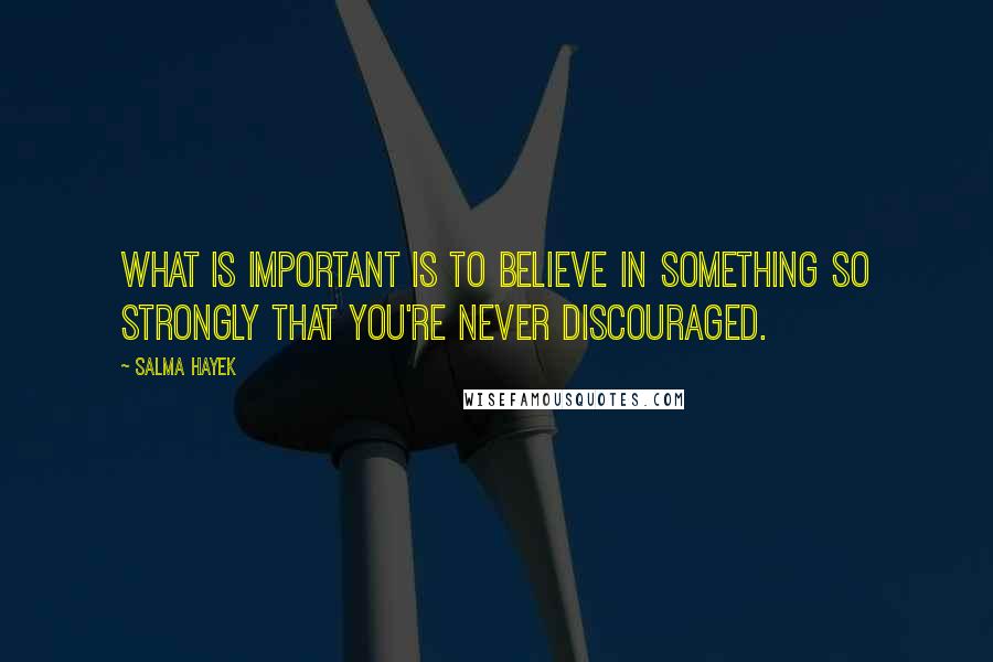 Salma Hayek Quotes: What is important is to believe in something so strongly that you're never discouraged.