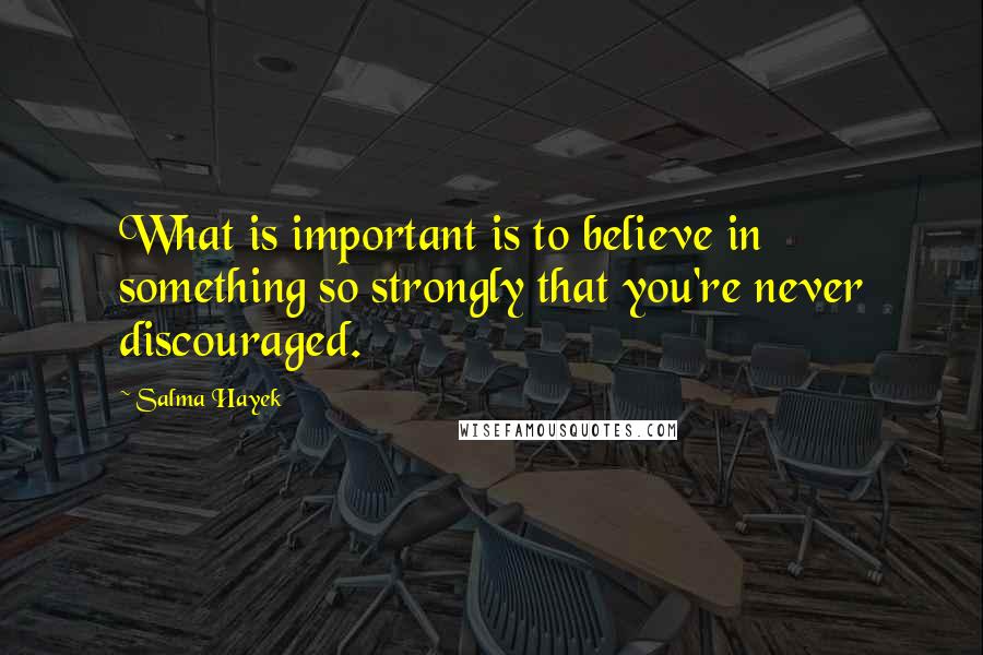 Salma Hayek Quotes: What is important is to believe in something so strongly that you're never discouraged.