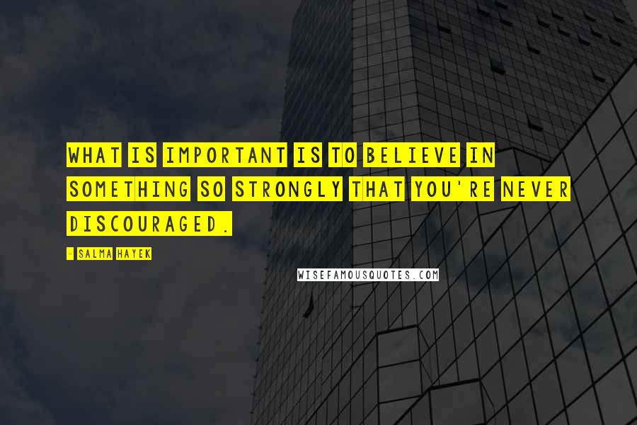 Salma Hayek Quotes: What is important is to believe in something so strongly that you're never discouraged.