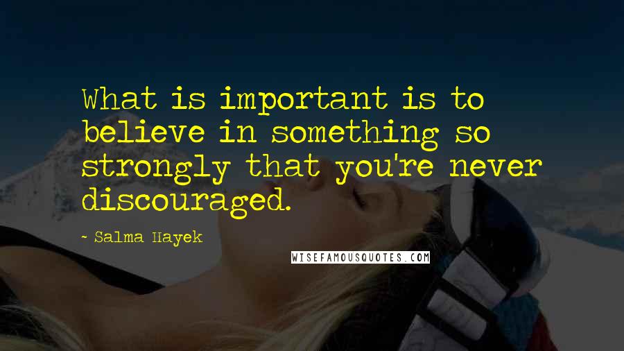 Salma Hayek Quotes: What is important is to believe in something so strongly that you're never discouraged.